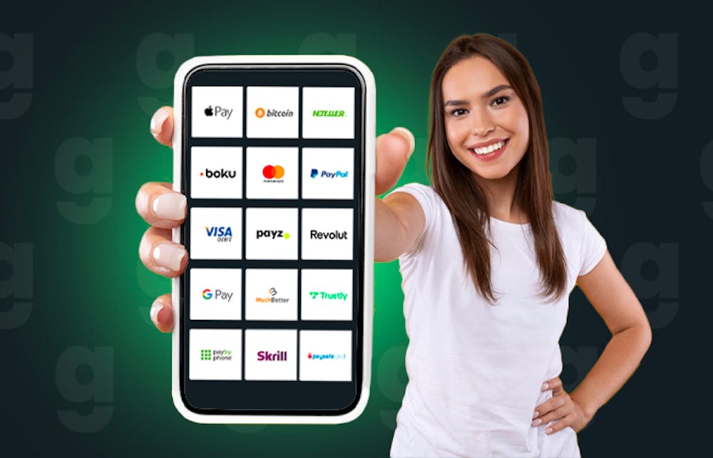 A woman holds up a mobile phone showing the most popular casino payment methods available in the UK
